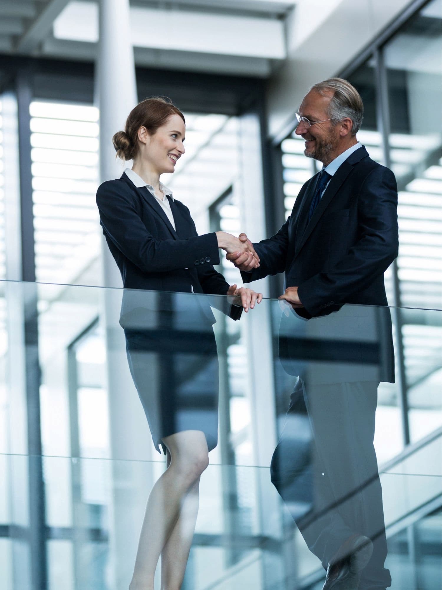 Corporate handshake employee milestone recognition Business professionals shaking hands in modern office